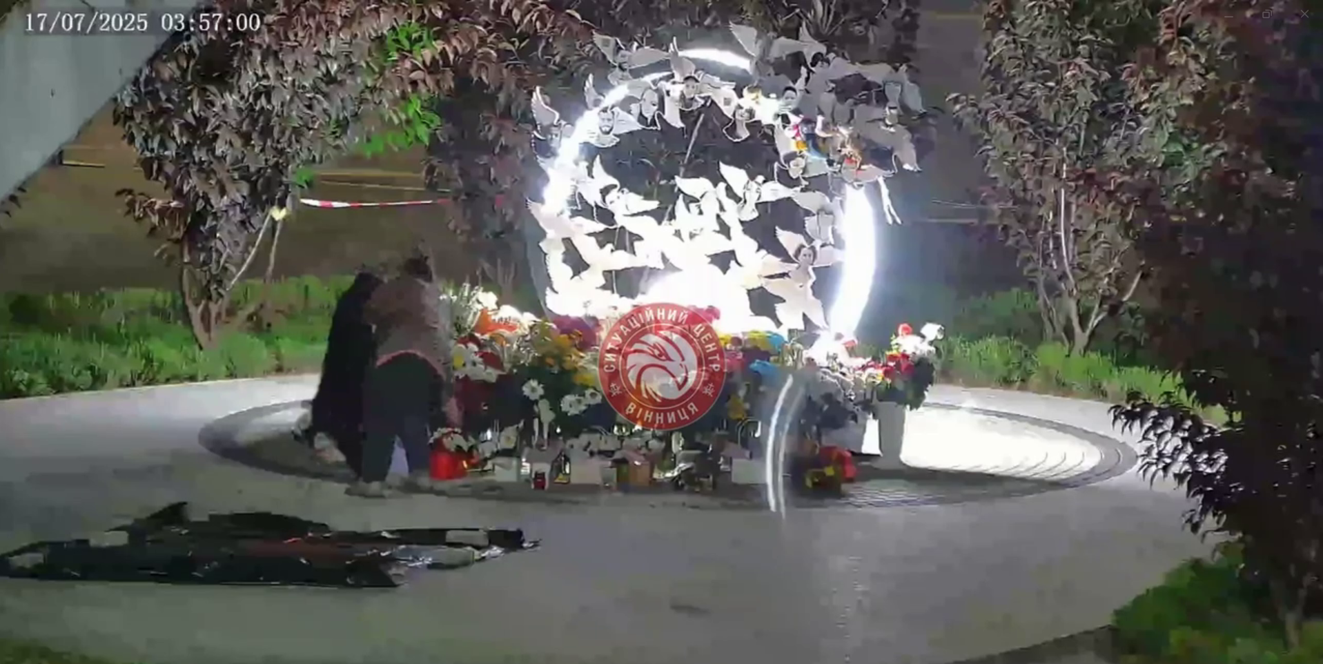 Новини Вінниці / Хреститься і краде: невідома жінка забрала квіти з меморіалу жертвам російського обстрілу у Вінниці